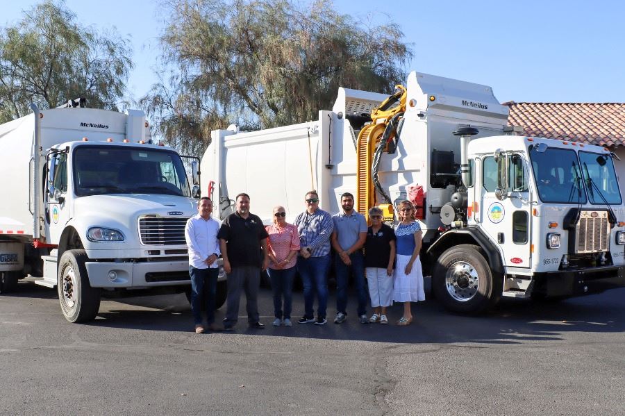 City Council in front of new public works side loaders and rear loader